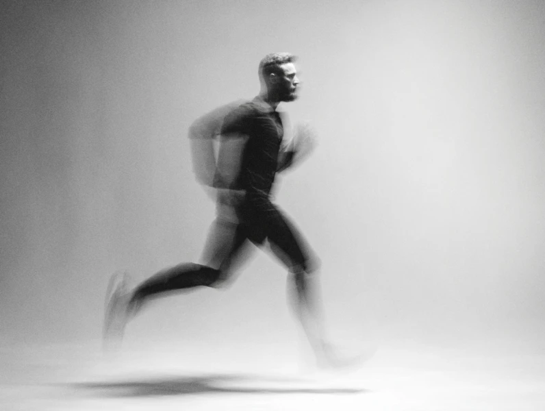 zwart-wit foto met bewegingsonscherpte van man die hardloopt 